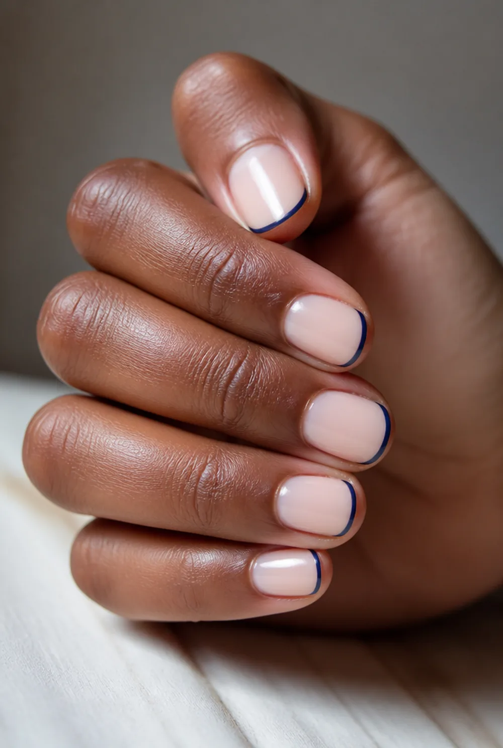 navy french tip nail art on deep brown skin