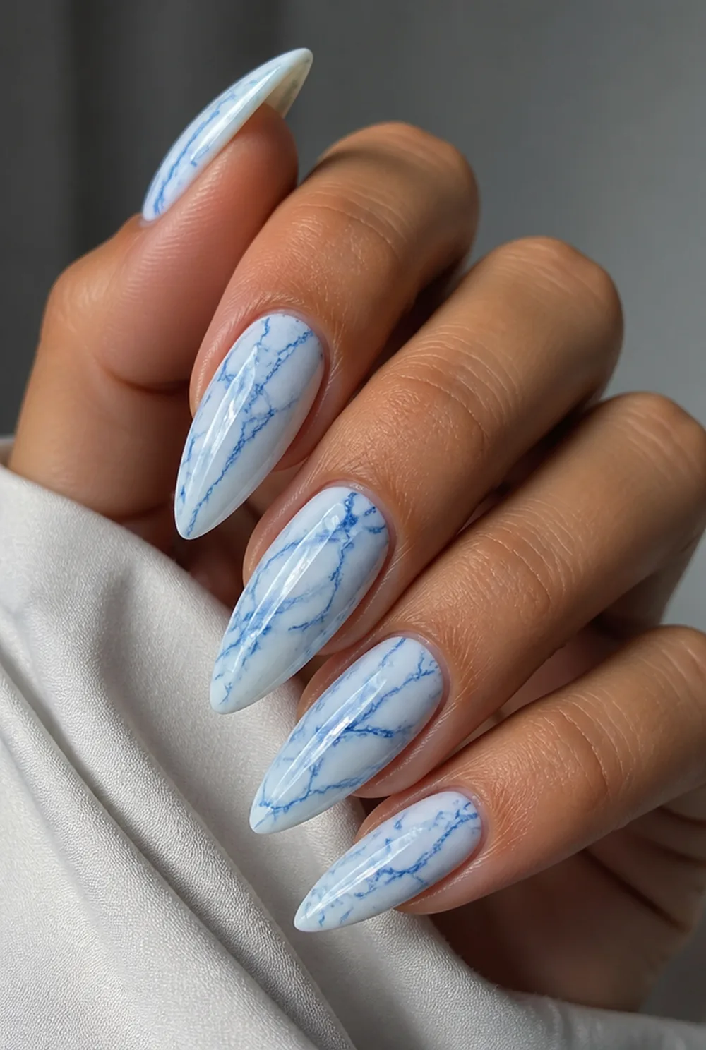 blue and white marble nail art on olive skin, long length