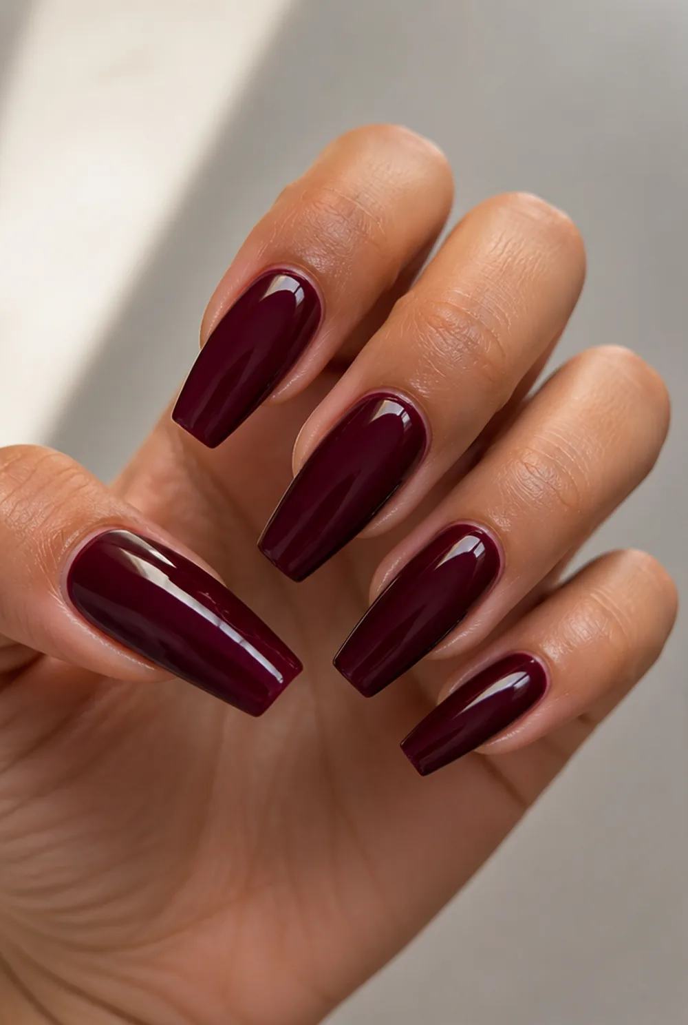 burgundy coffin nail art on olive skin, long length