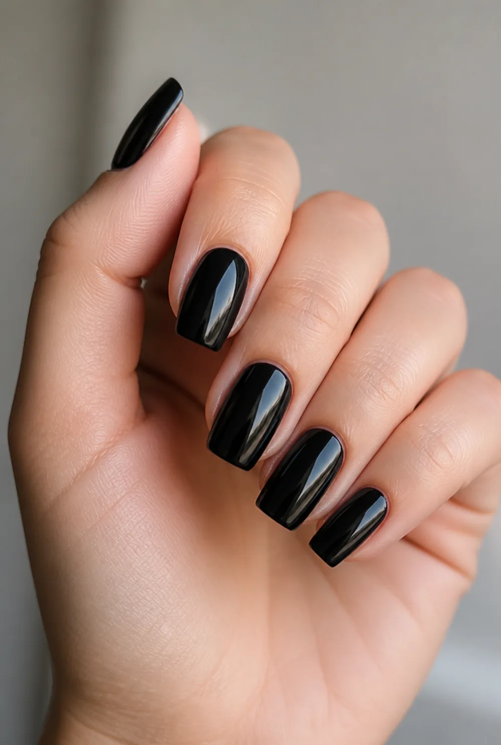 black coffin gloss nail art on fair skin, short length