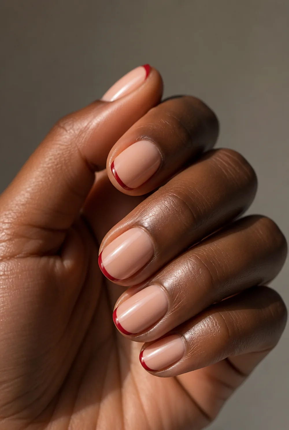 red french tip nail art on deep brown skin