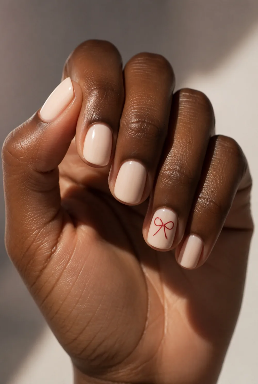 bow accent nail art on deep brown skin