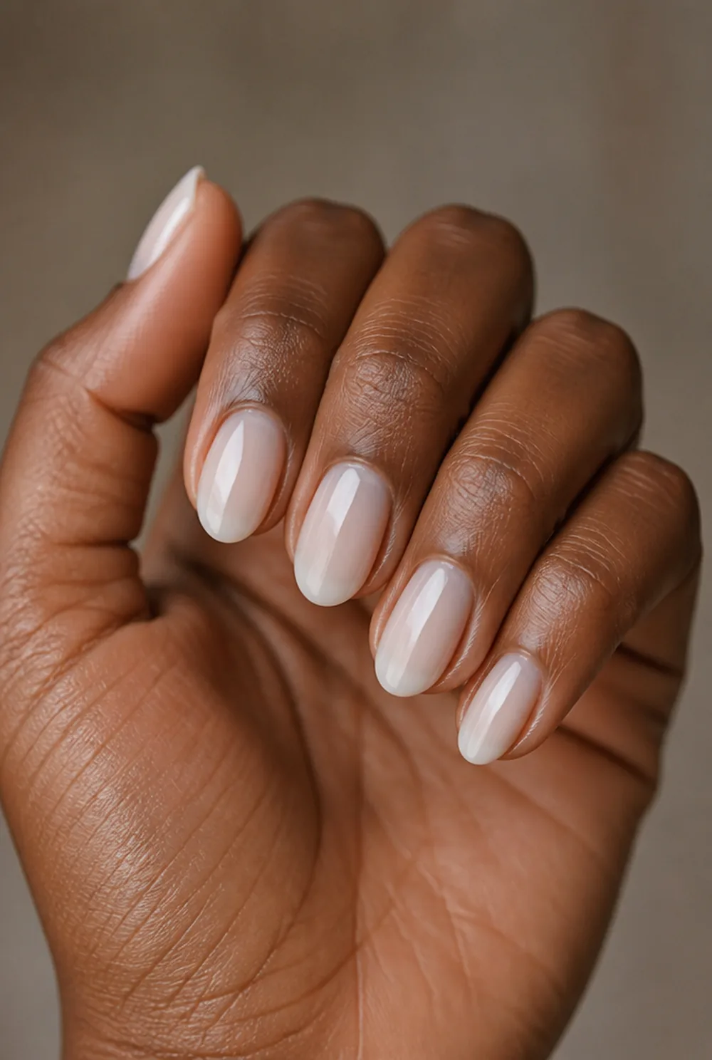 milky white nail art on deep brown skin
