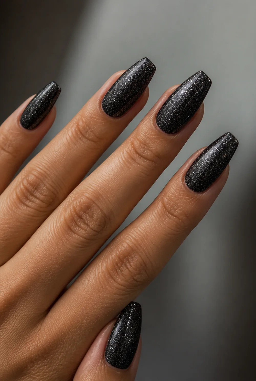 glitter over black nail art on olive skin, long length
