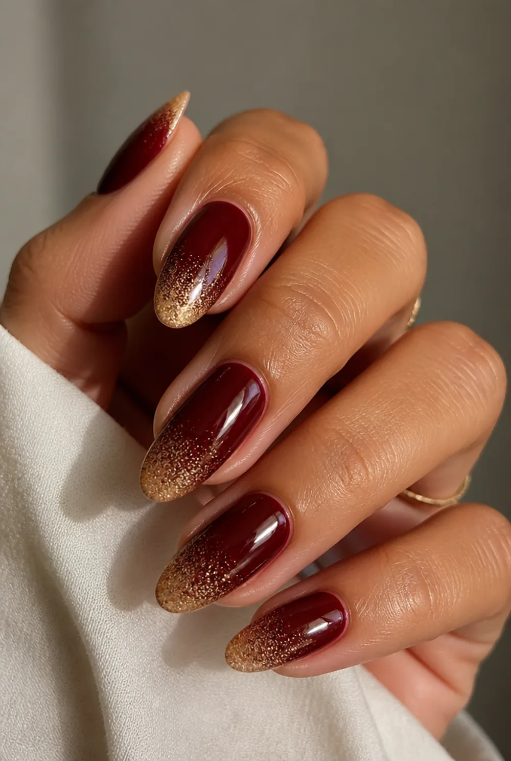 glitter over burgundy nail art on olive skin, long length