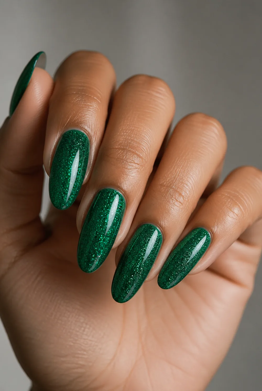 glitter over emerald nail art on olive skin, long length