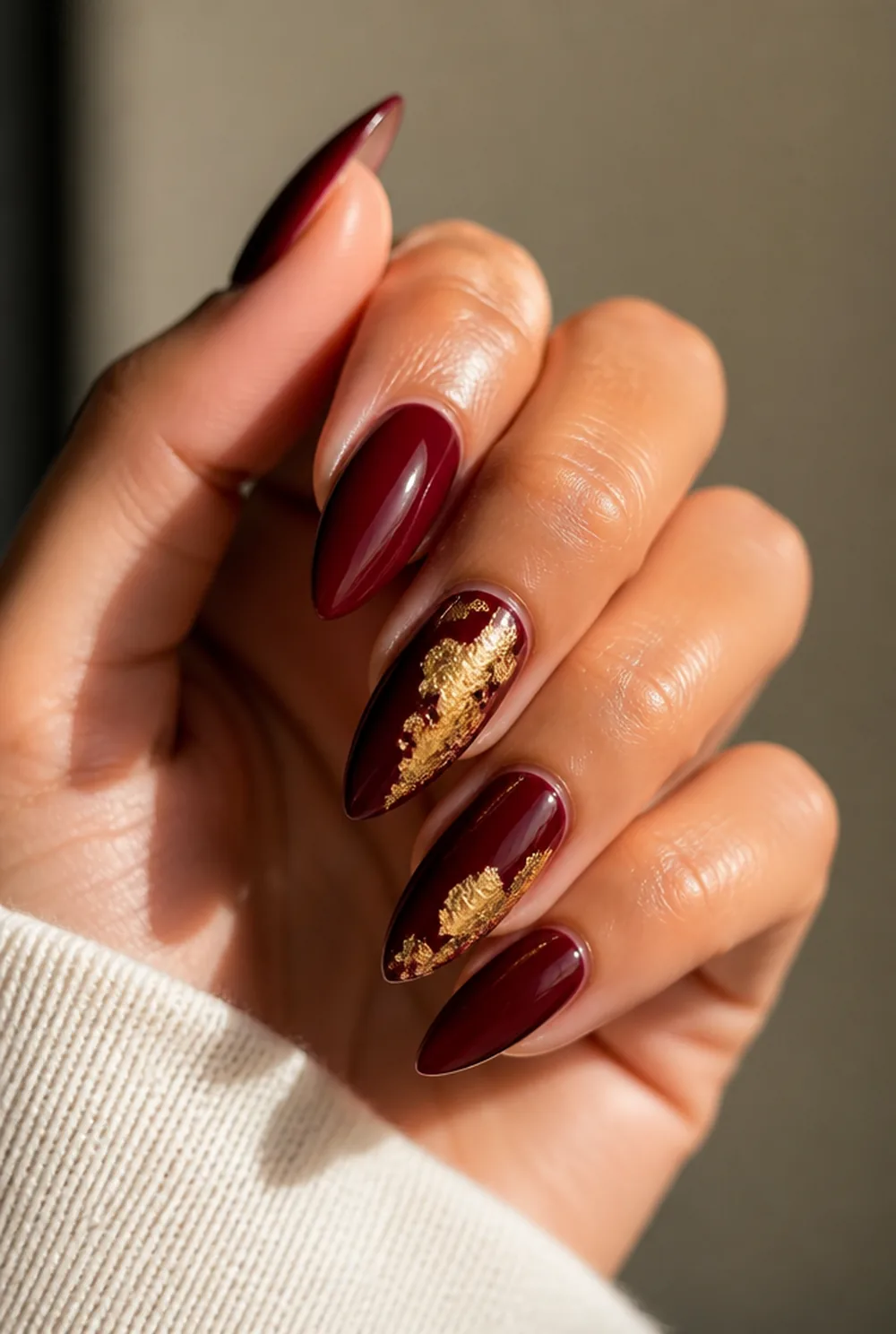 gold and burgundy nail art on olive skin, long length