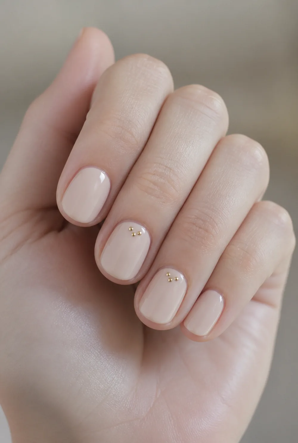 gold dot cluster nail art on fair skin, short length