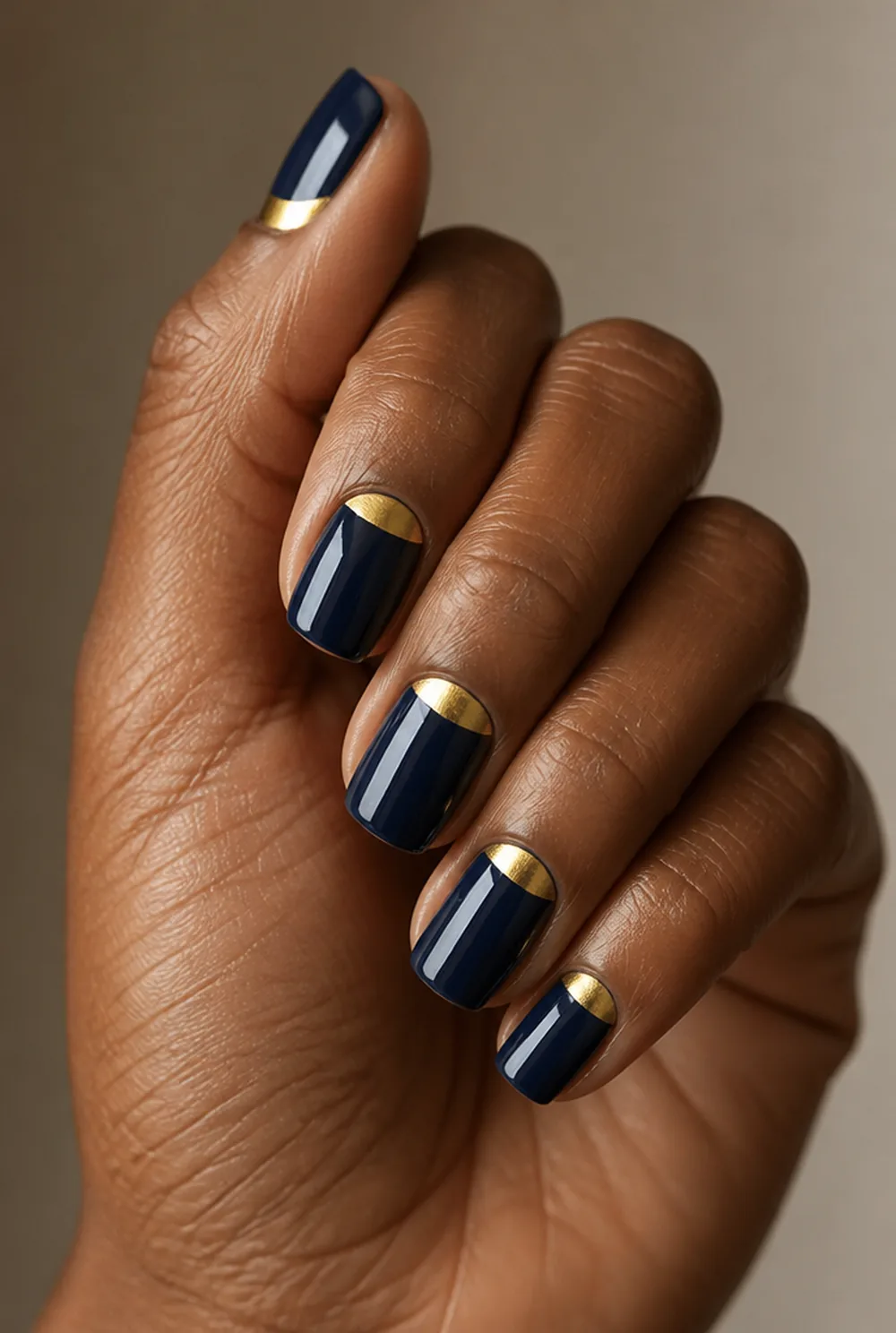 gold half moon nail art on deep brown skin