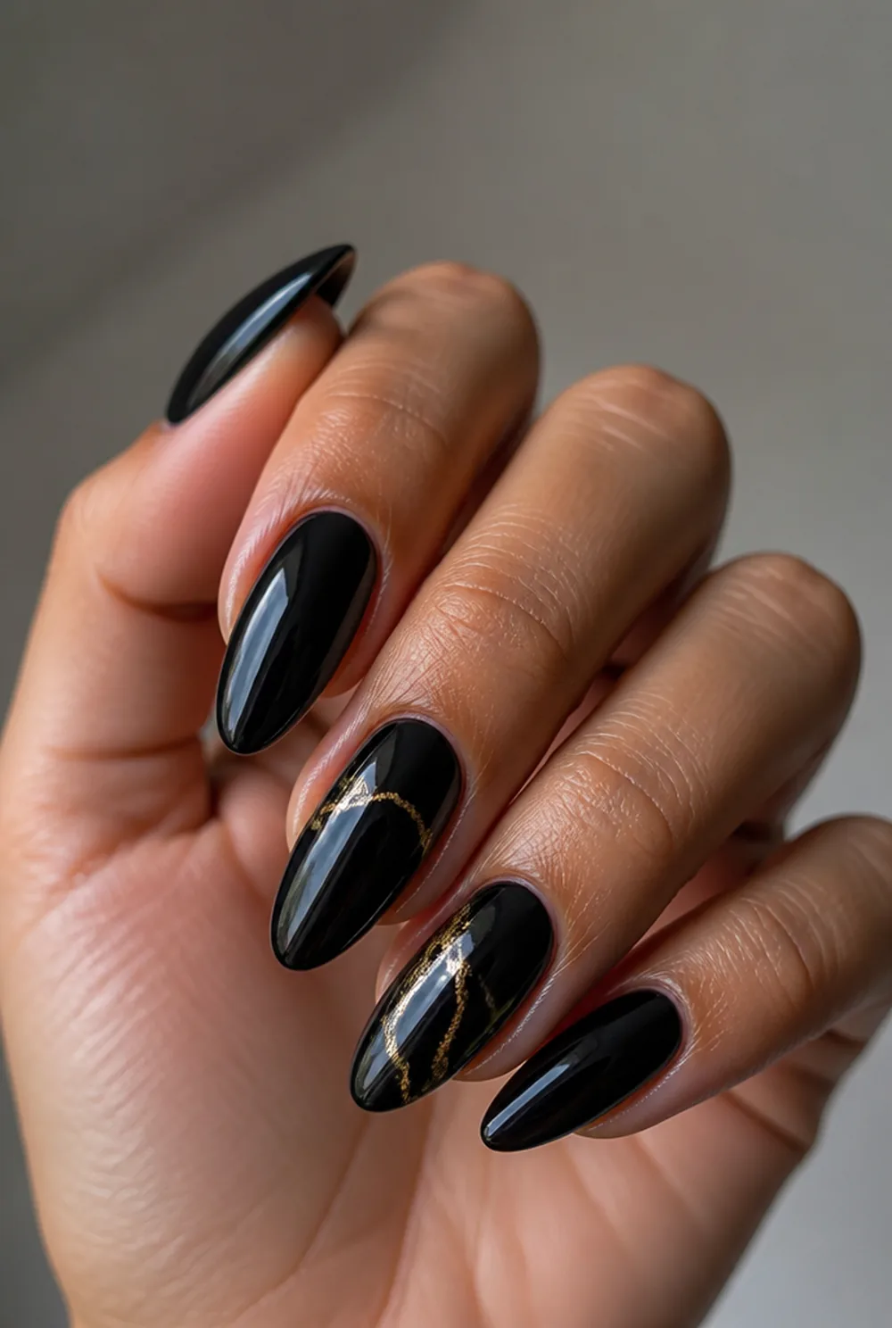 gold and black nail art on olive skin, long length