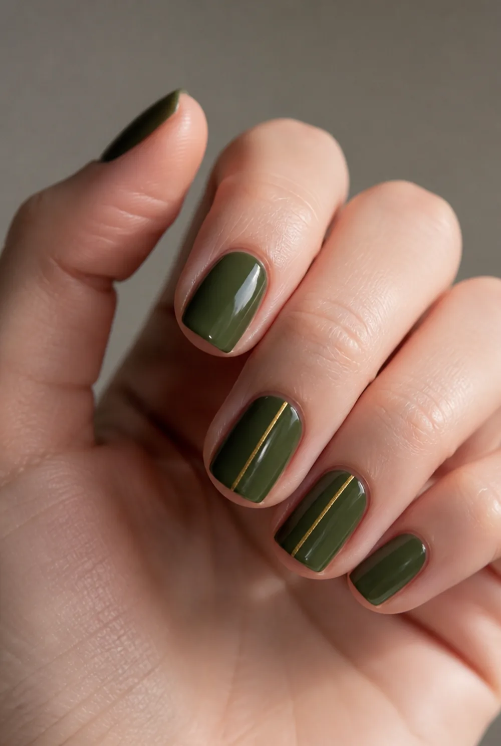 green and gold nail art on fair skin, short length