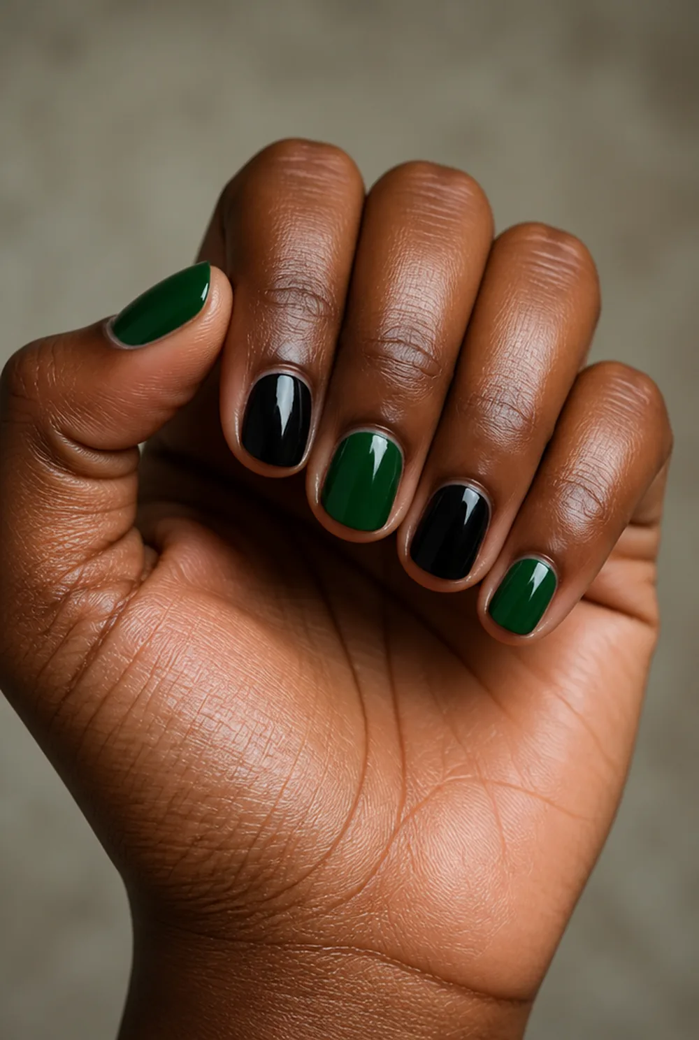 green and black nail art on deep brown skin