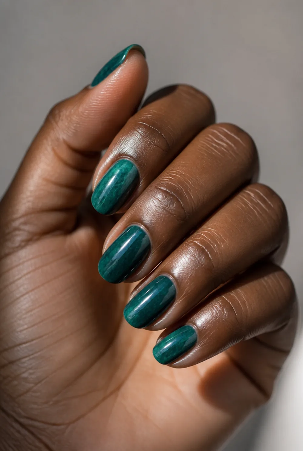teal nail art on deep brown skin