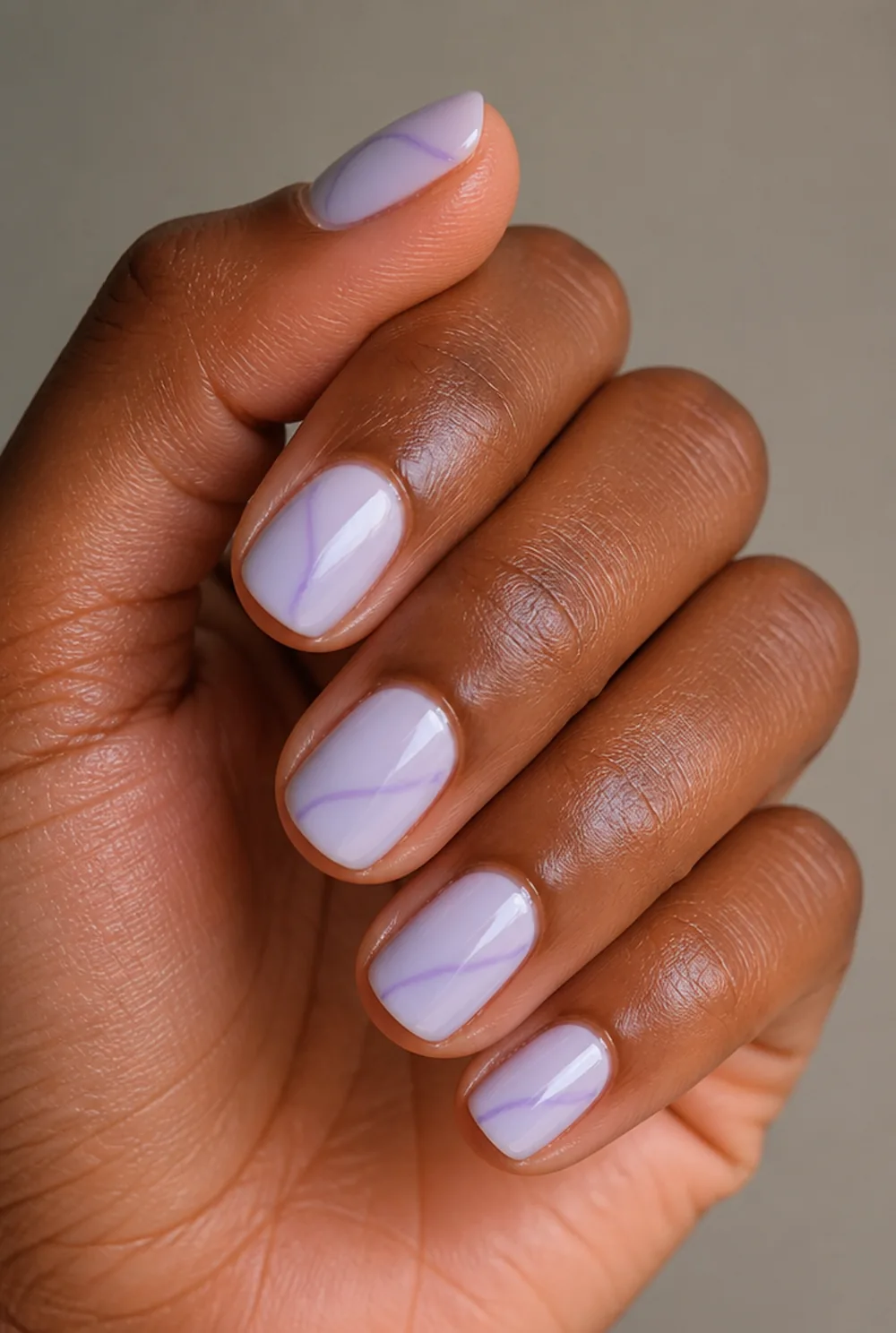 lavender swirl nail art on deep brown skin