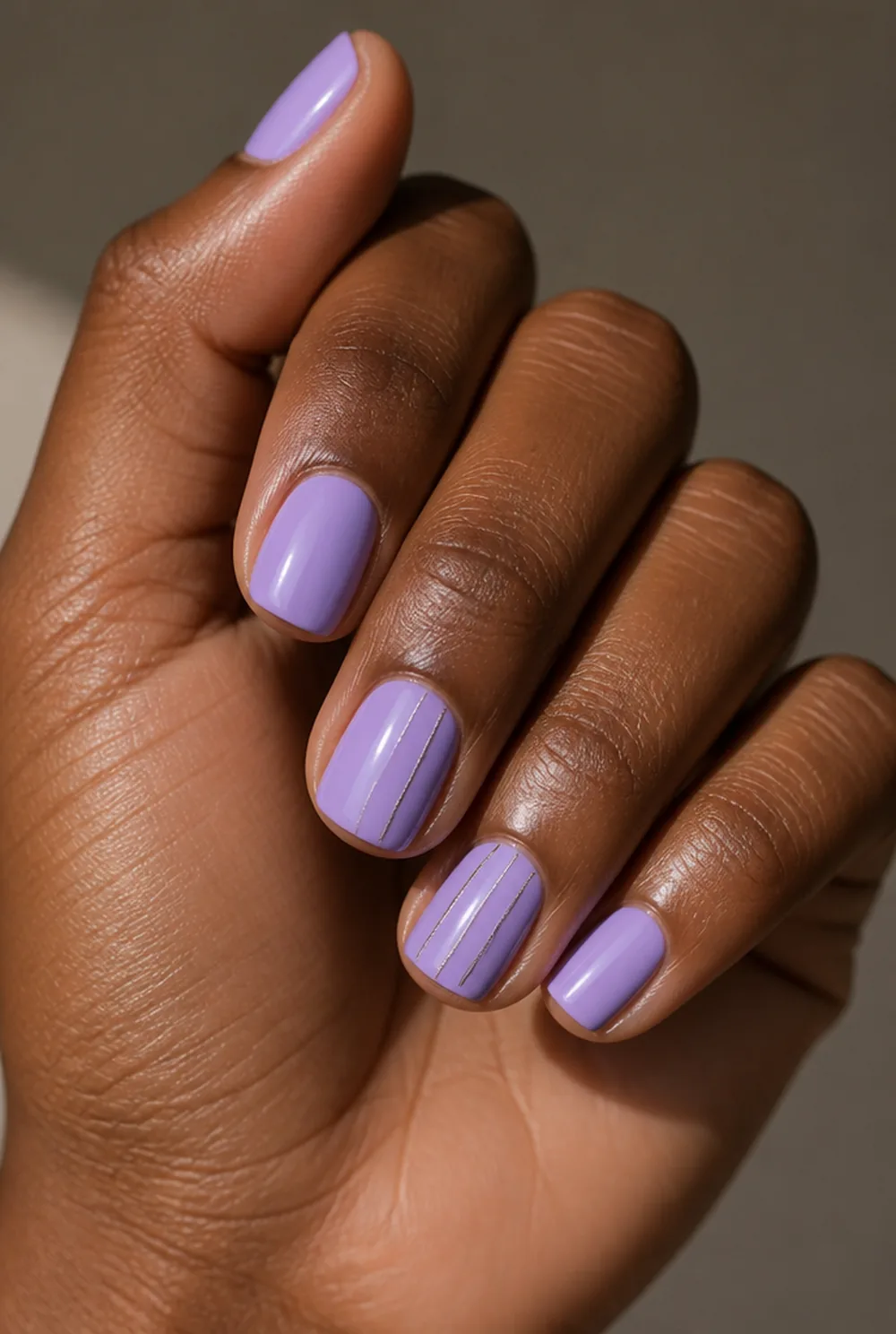 lavender and silver nail art on deep brown skin