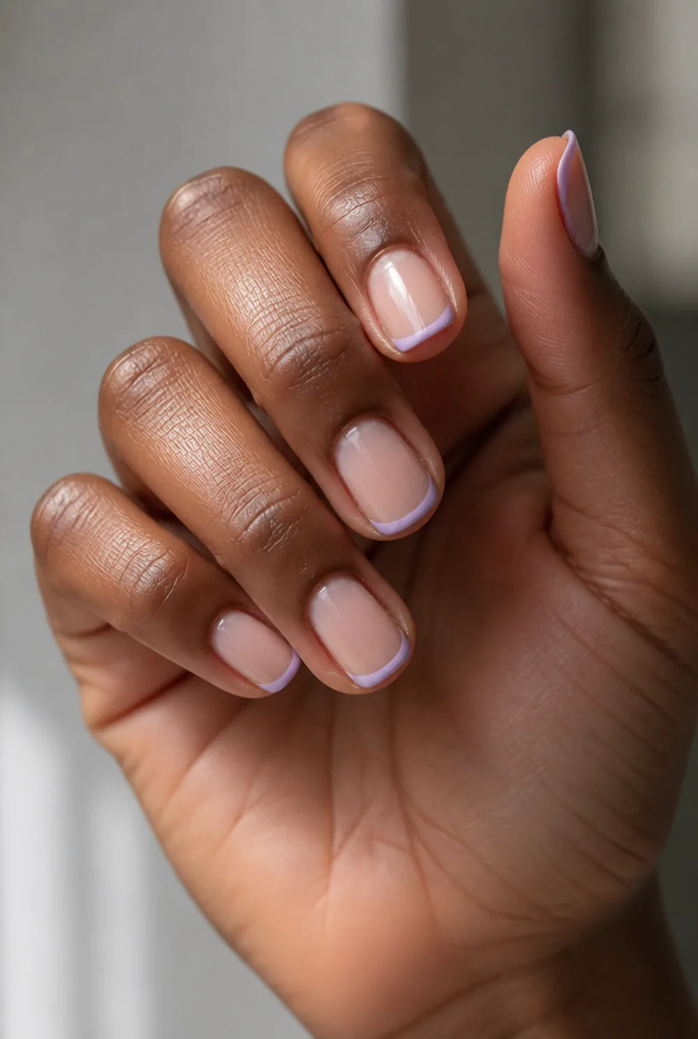 lavender french tip nail art on deep brown skin