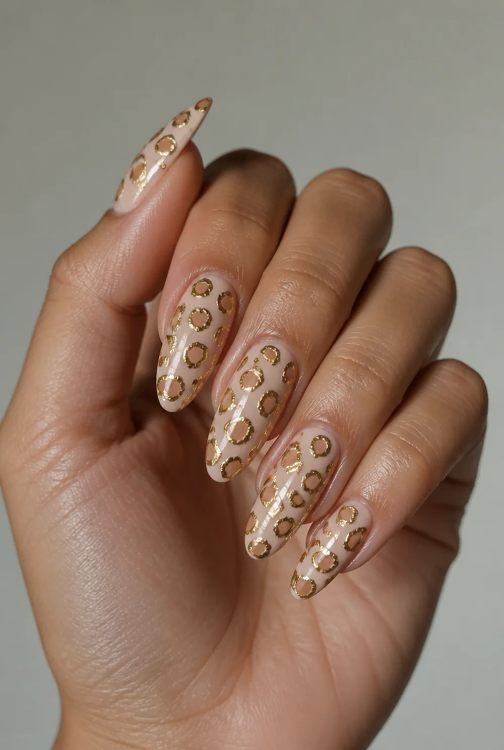 gold outline leopard nail art on olive skin, long length