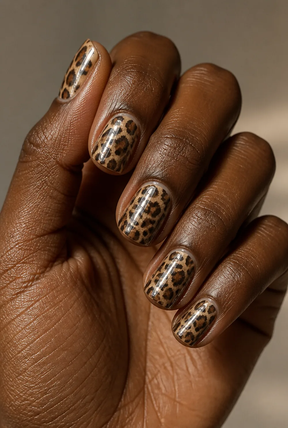 leopard with chrome overlay nail art on deep brown skin