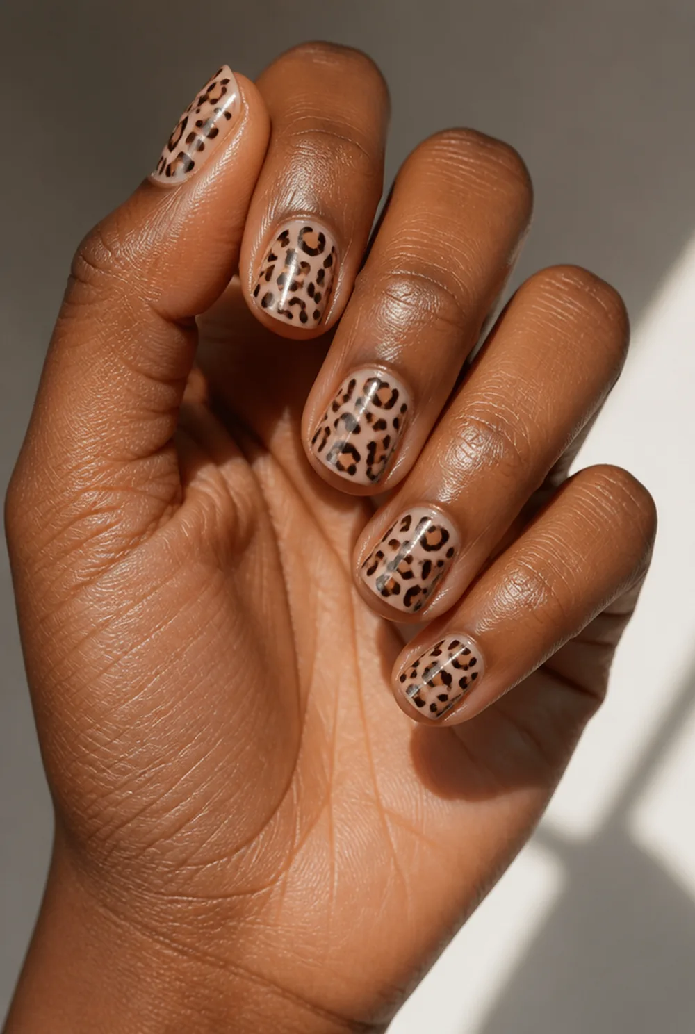 negative space leopard nail art on deep brown skin
