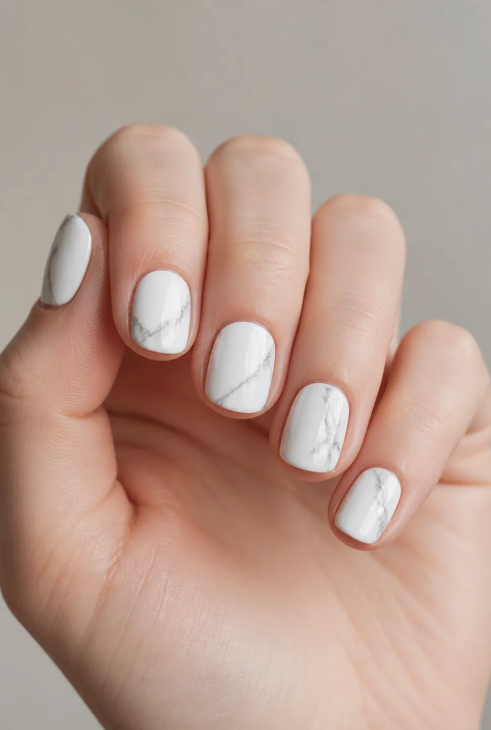 white carrara nail art on fair skin, short length