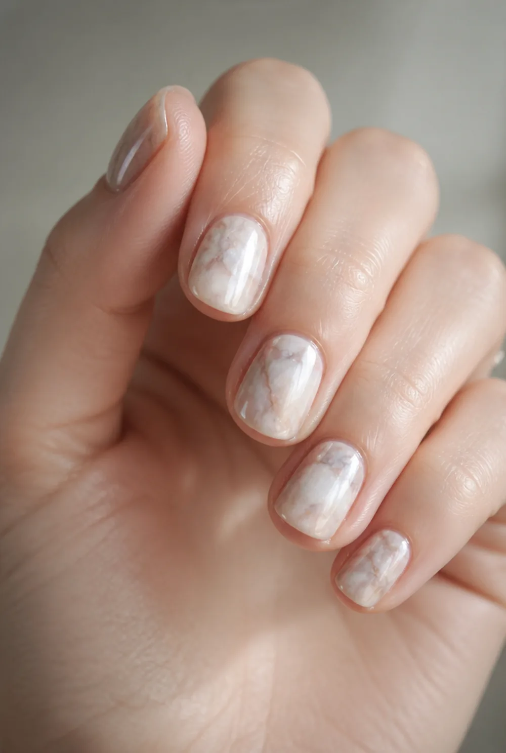 marble with chrome overlay nail art on fair skin, short length