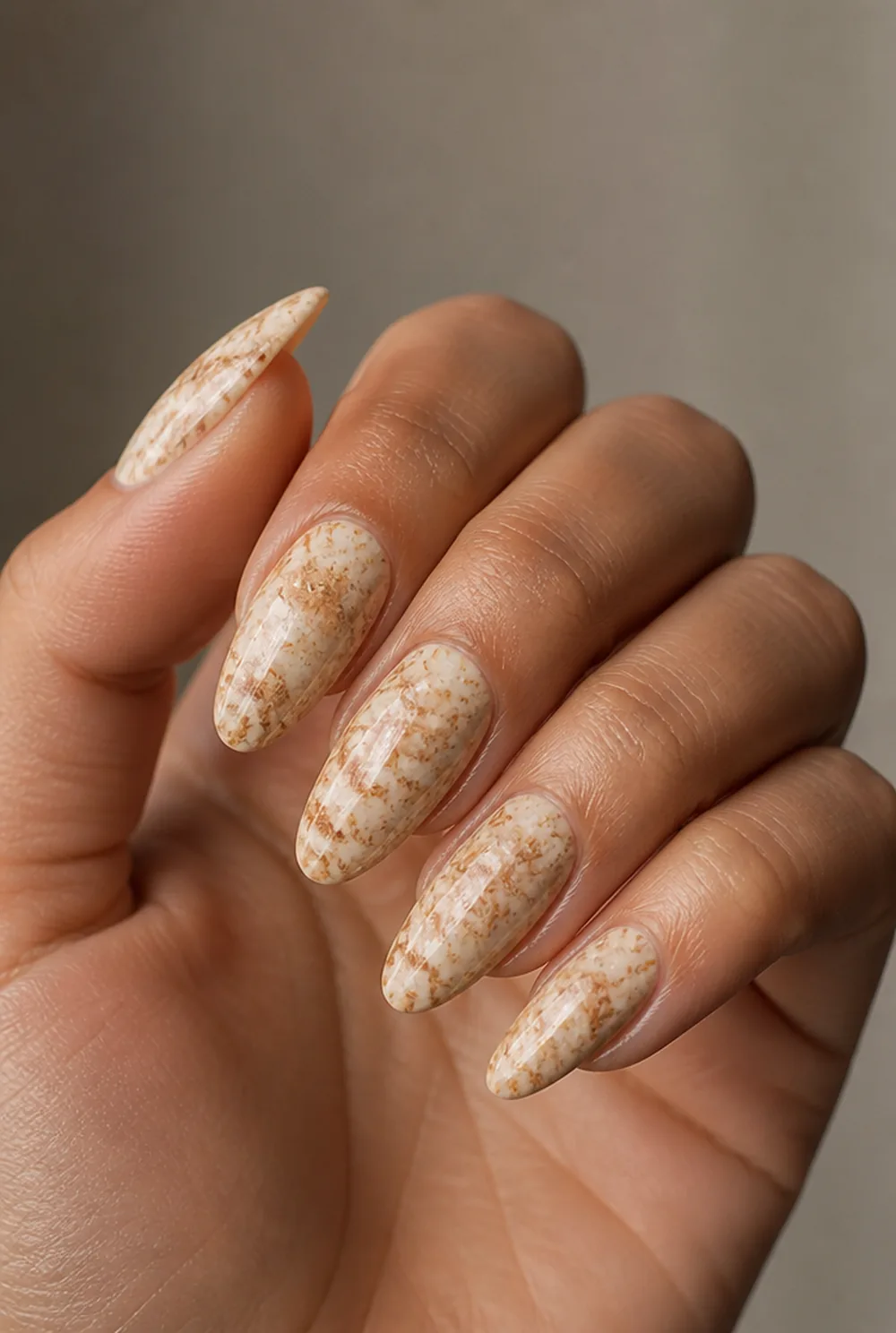 brown travertine nail art on olive skin, long length