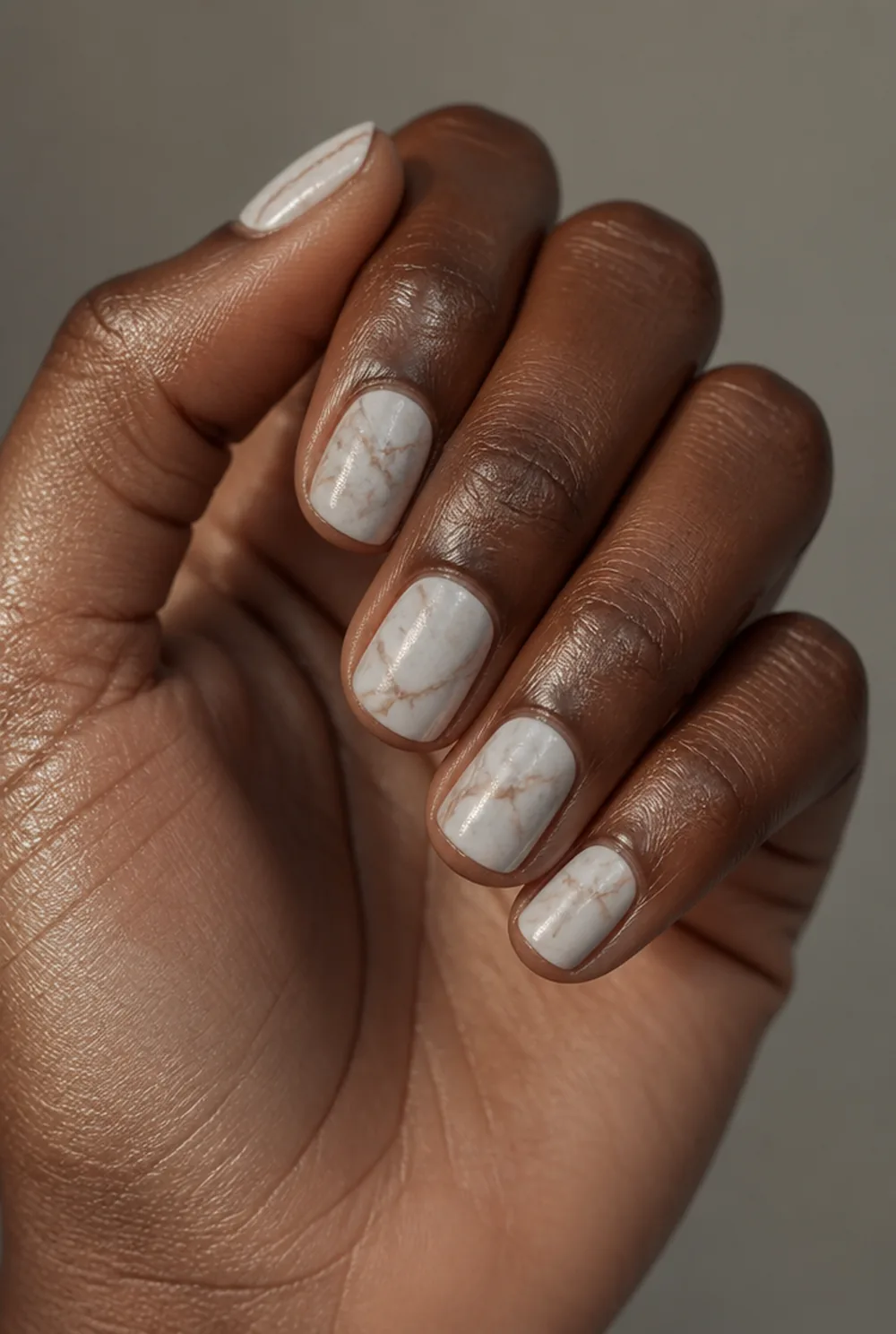matte marble nail art on deep brown skin
