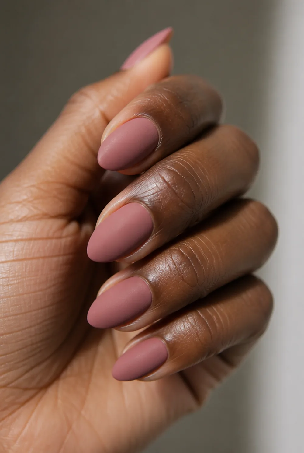 matte pink nail art on deep brown skin