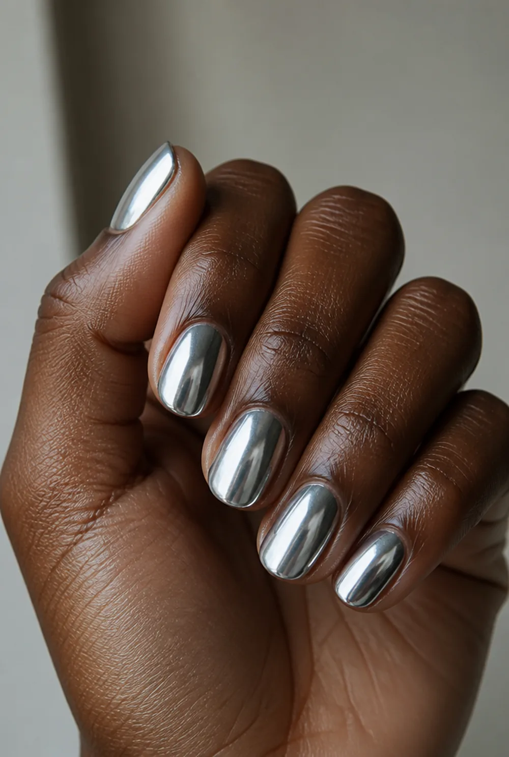 medium chrome nail art on deep brown skin