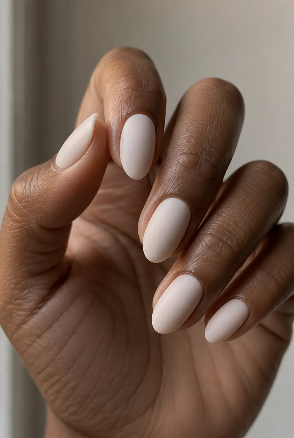 milky white matte nail art on deep brown skin