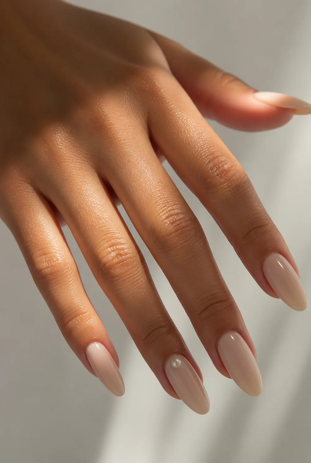 single pearl nail art on olive skin, long length