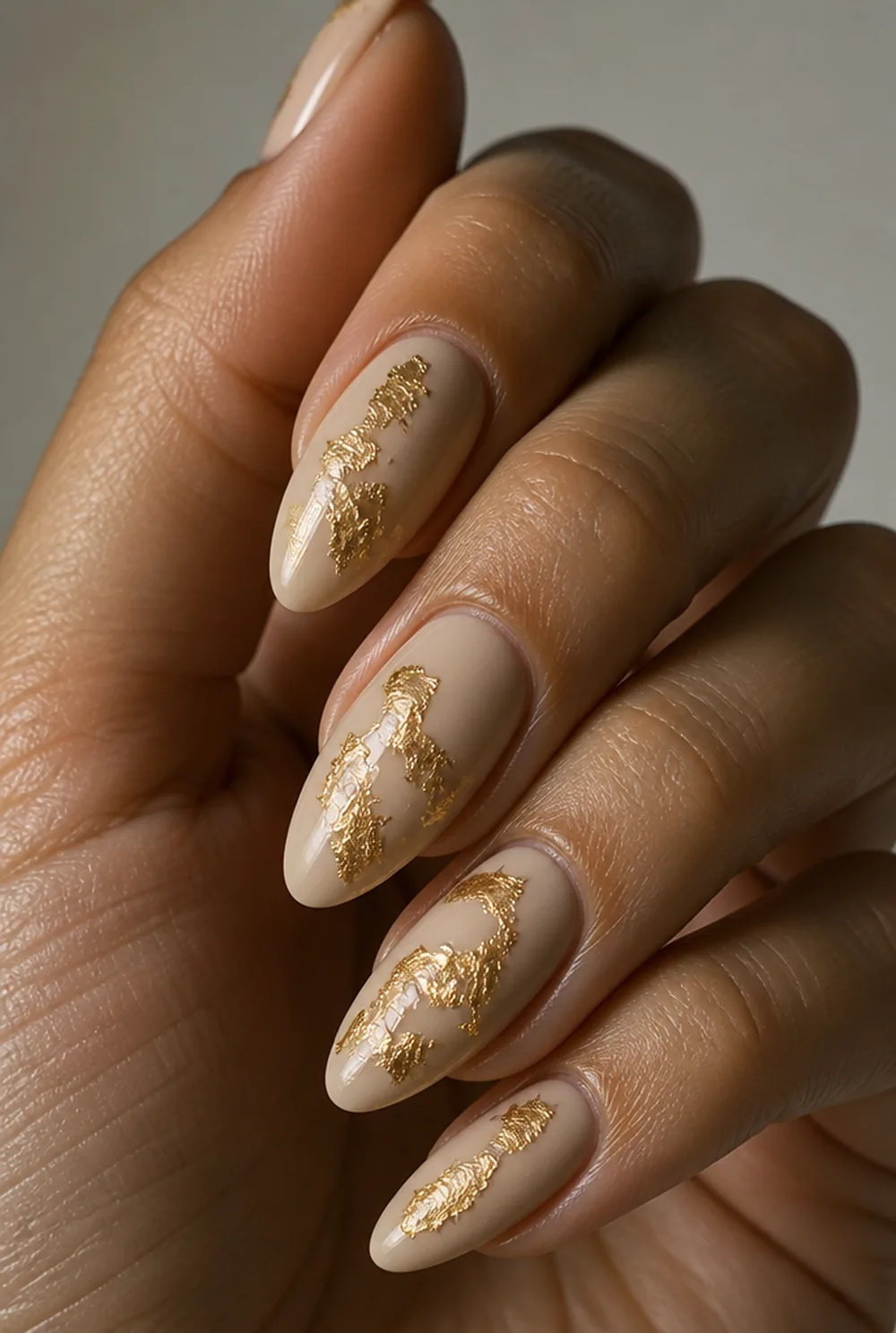 nude with gold foil nail art on olive skin, long length