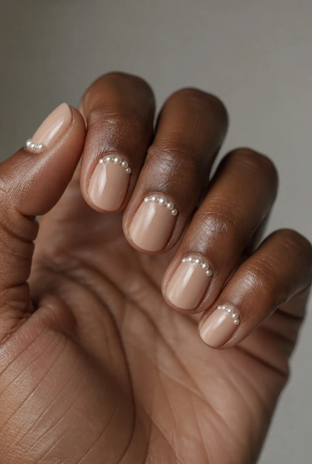 nude with pearl cuff nail art on deep brown skin