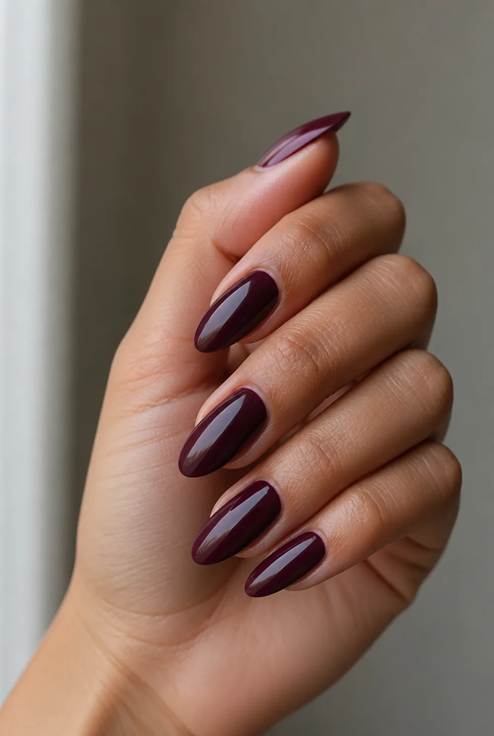 deep plum nail art on olive skin, long length