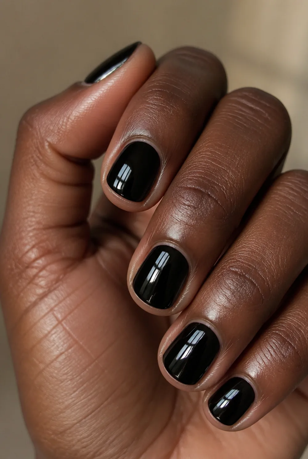 glossy black short nail art on deep brown skin