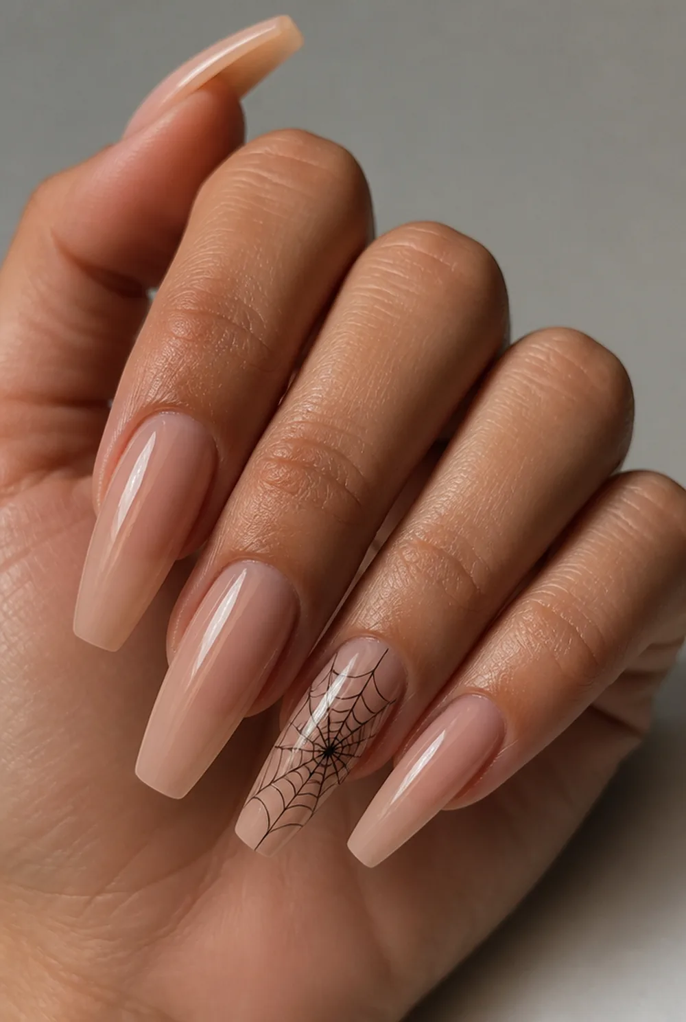 single spiderweb nail art on olive skin, long length