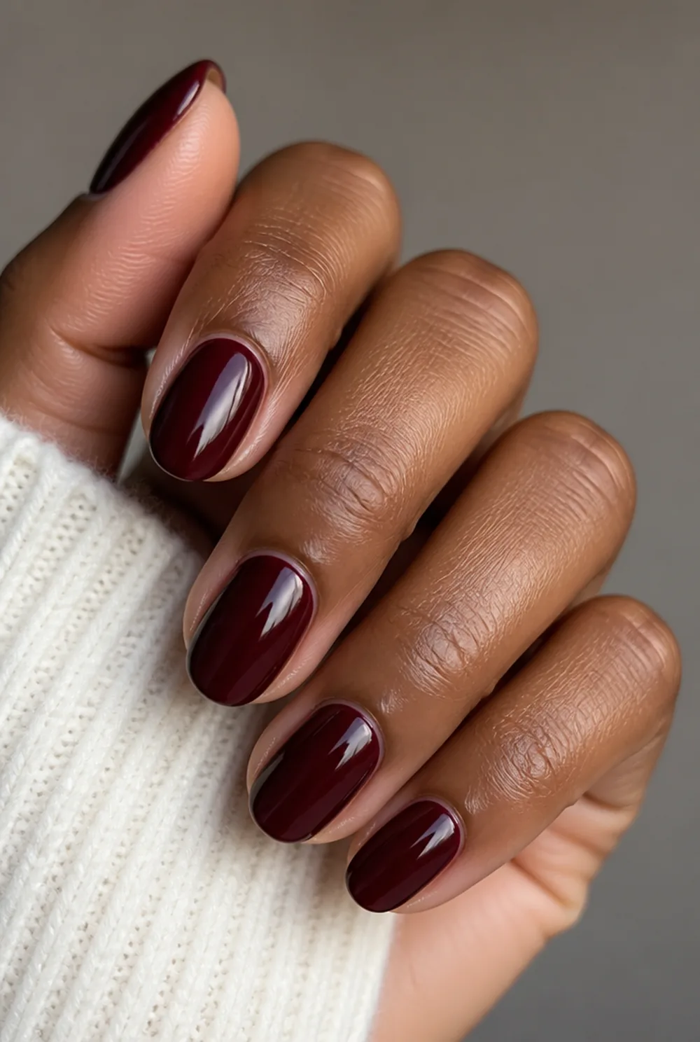 long oval burgundy nail art on deep brown skin