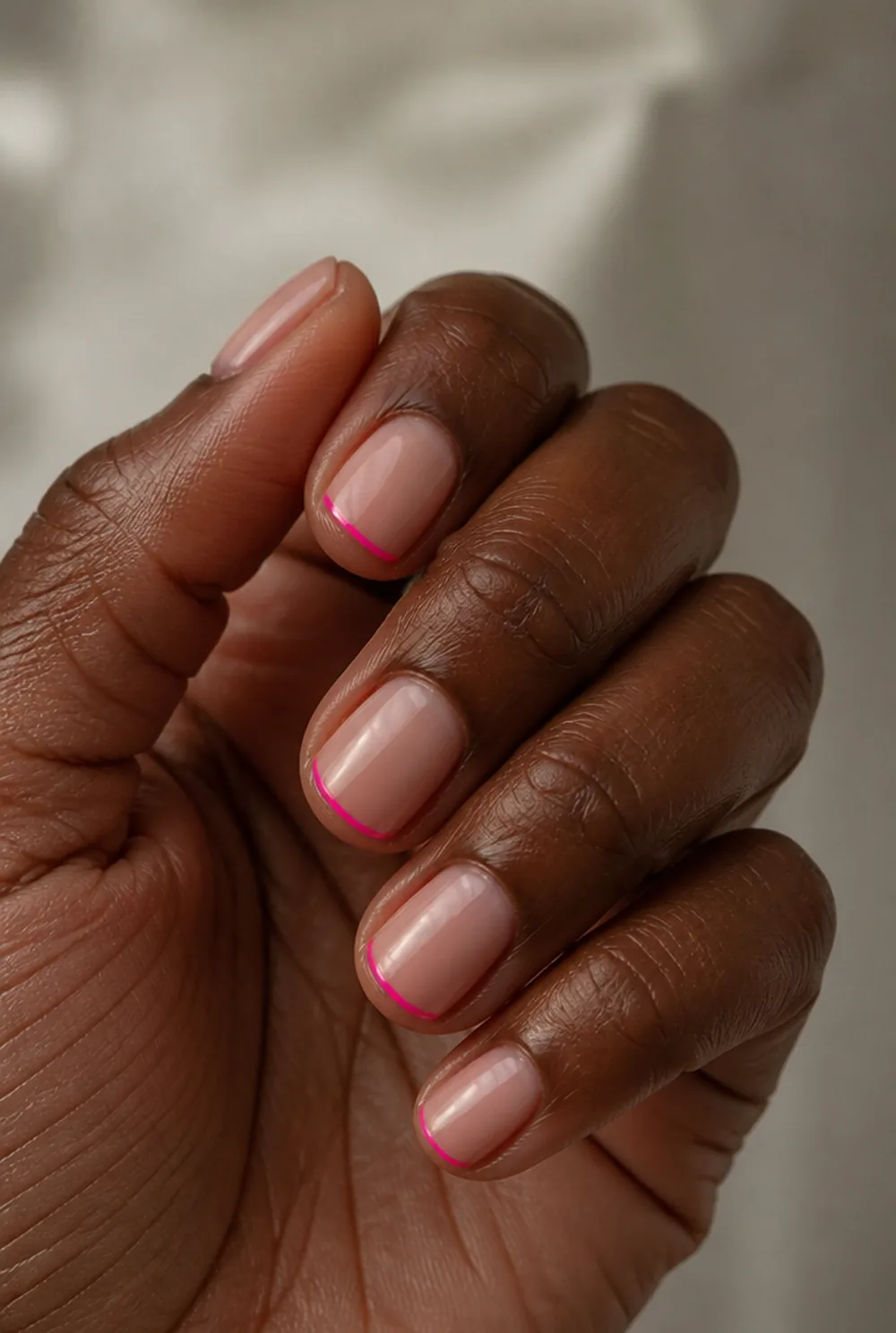 pink micro french nail art on deep brown skin