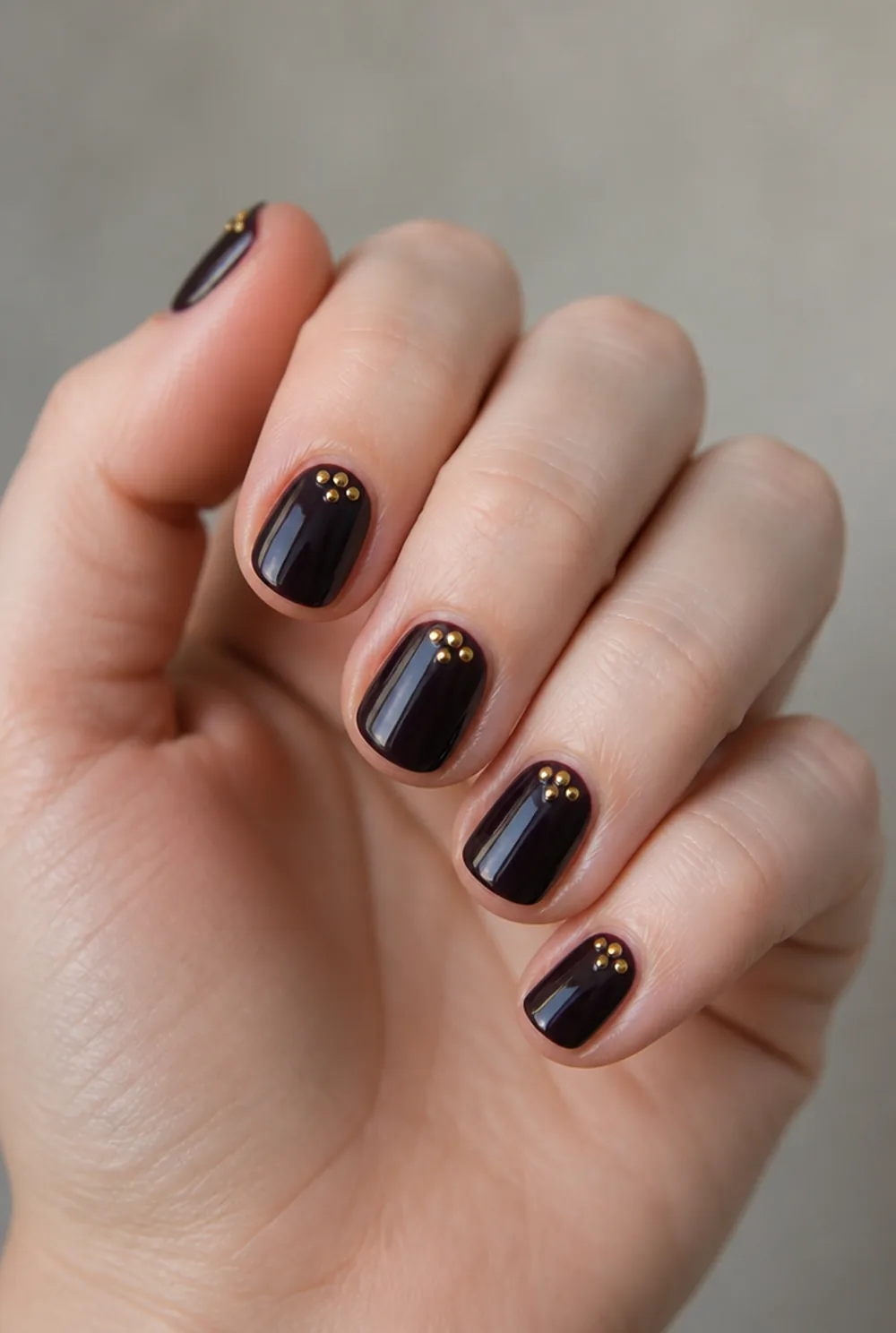 gold dot cluster nail art on fair skin, short length