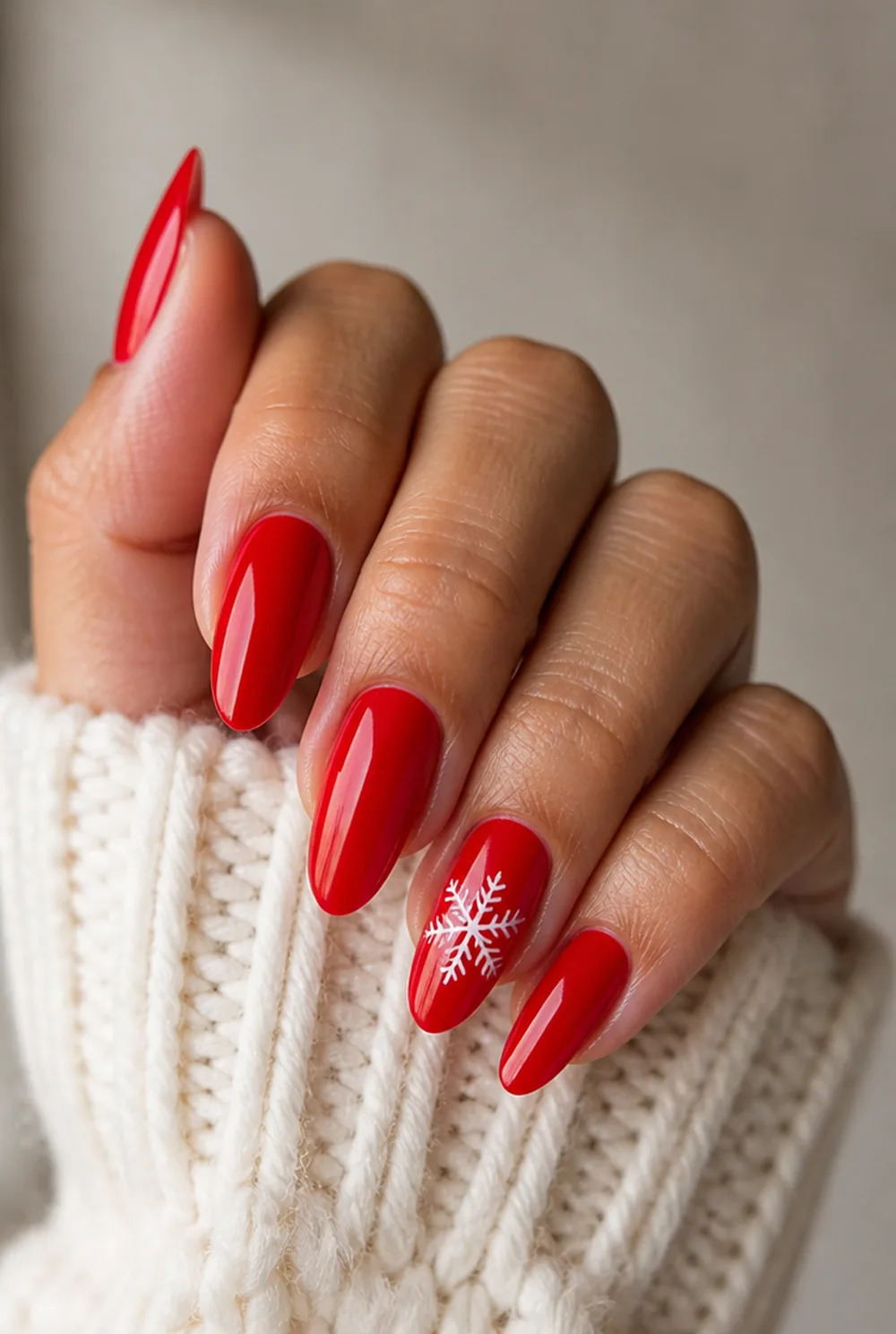 red with white snowflake nail art on olive skin, long length