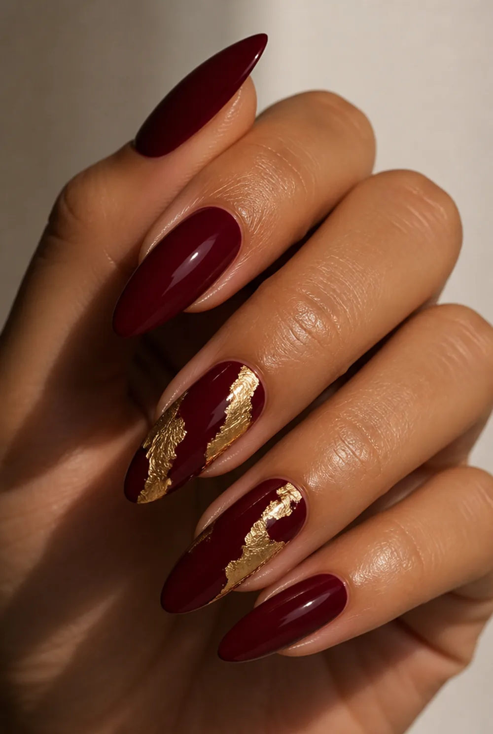 red and gold foil nail art on olive skin, long length