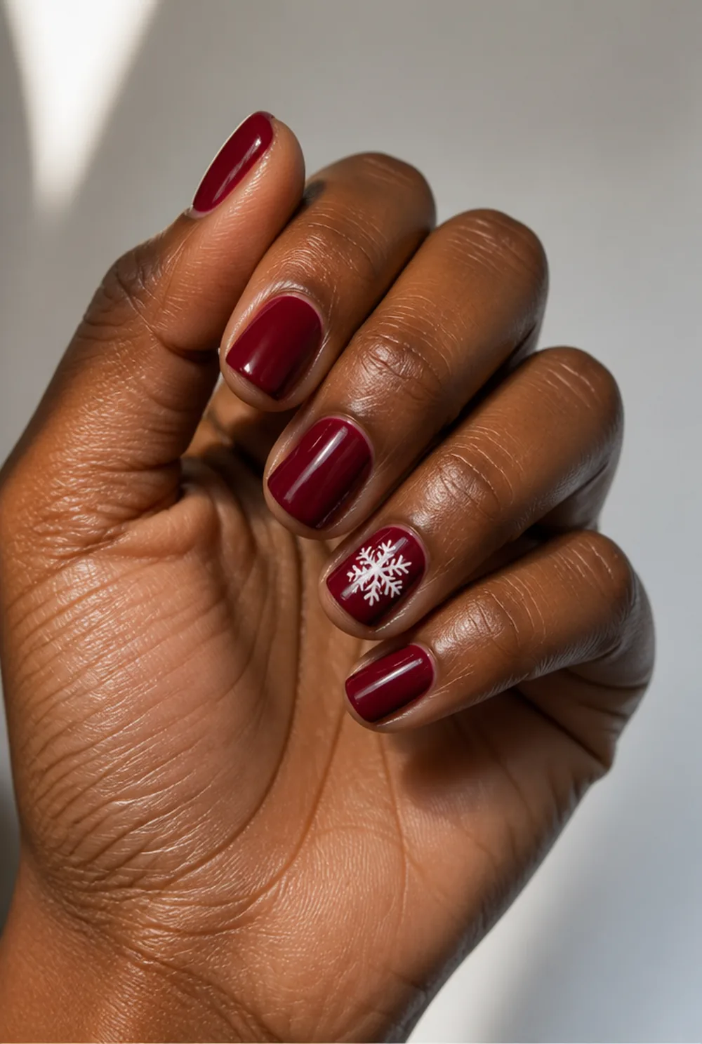 snowflake on red nail art on deep brown skin