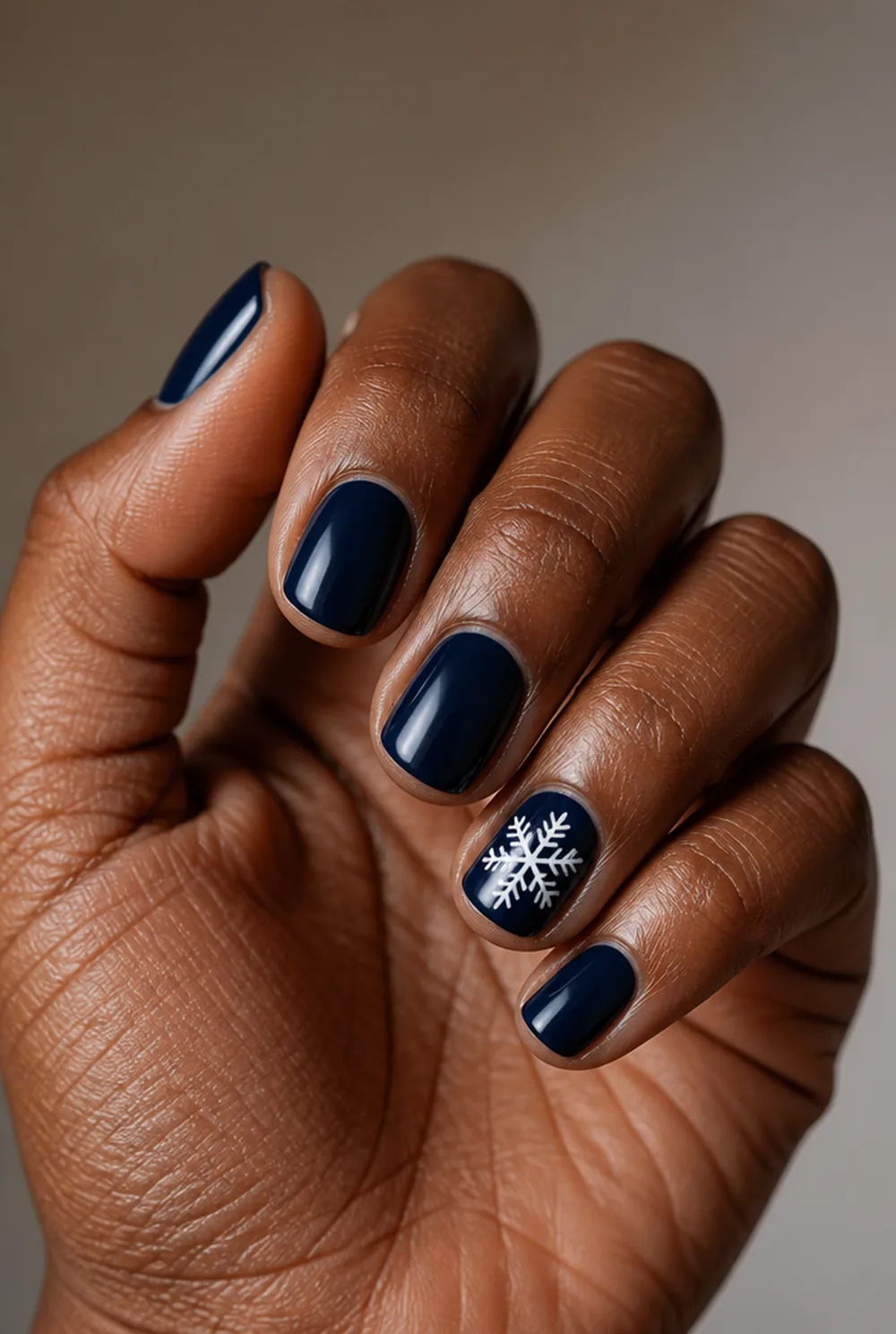 white flake on navy nail art on deep brown skin