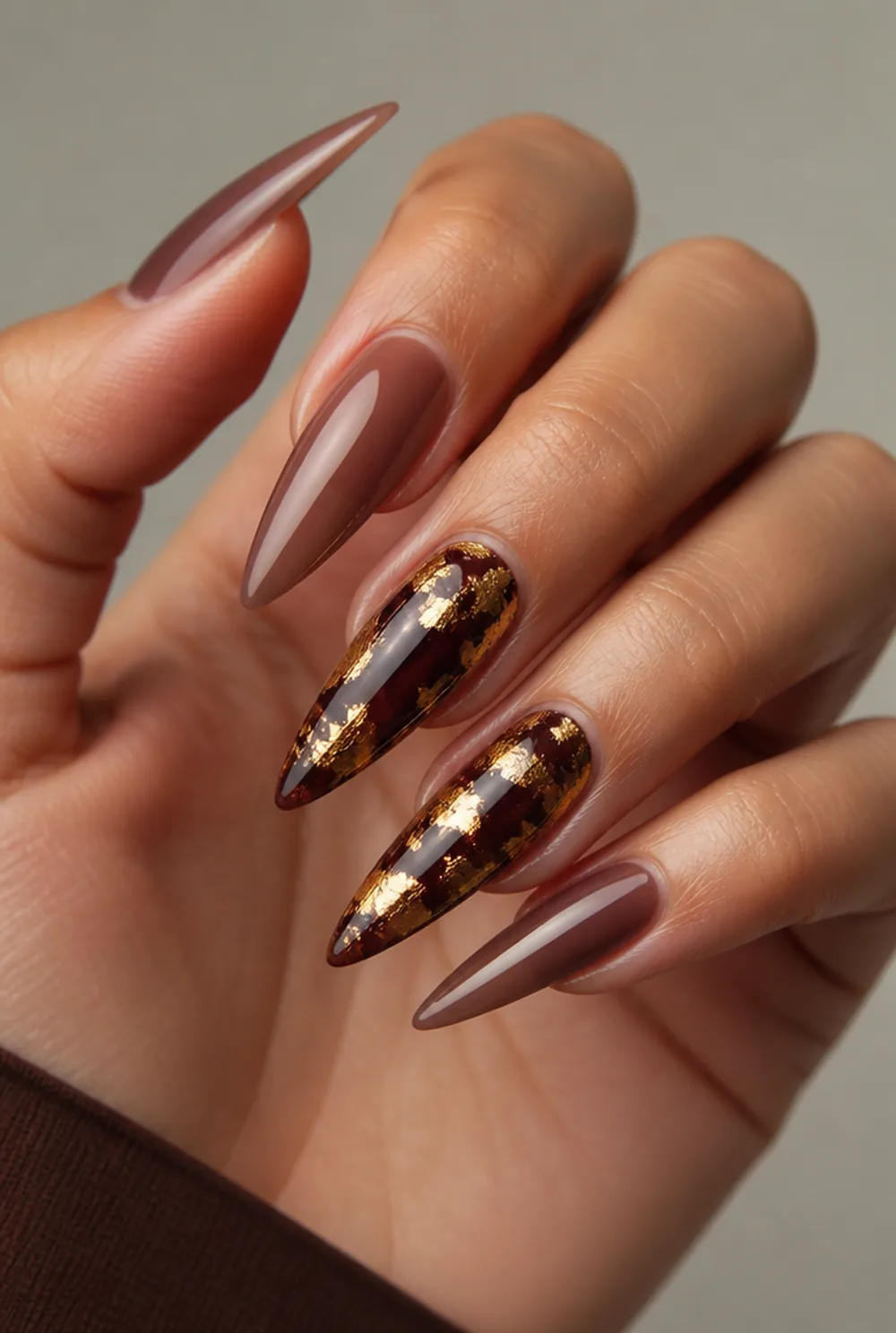 stiletto with gold foil nail art on olive skin, long length