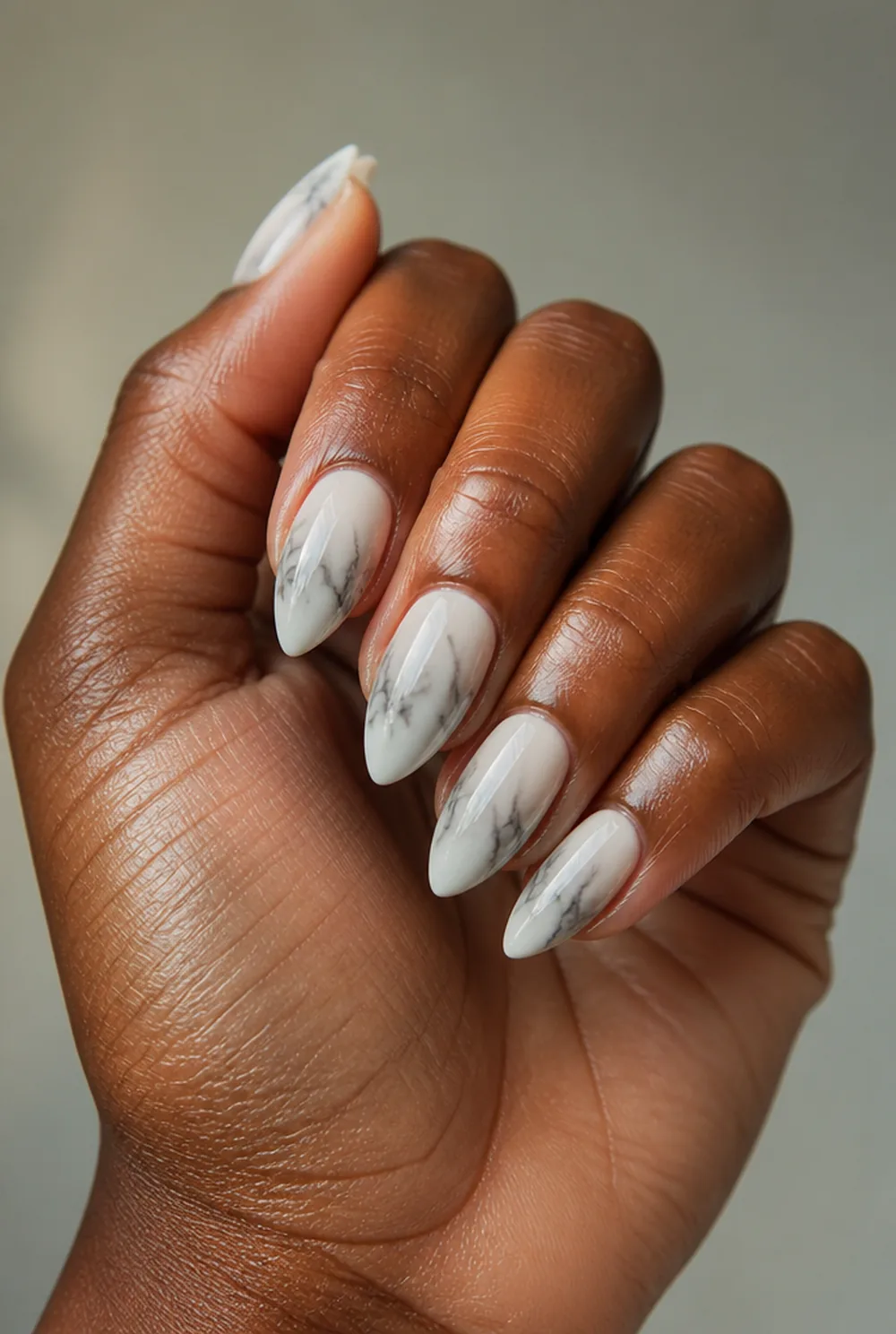 stiletto marble nail art on deep brown skin