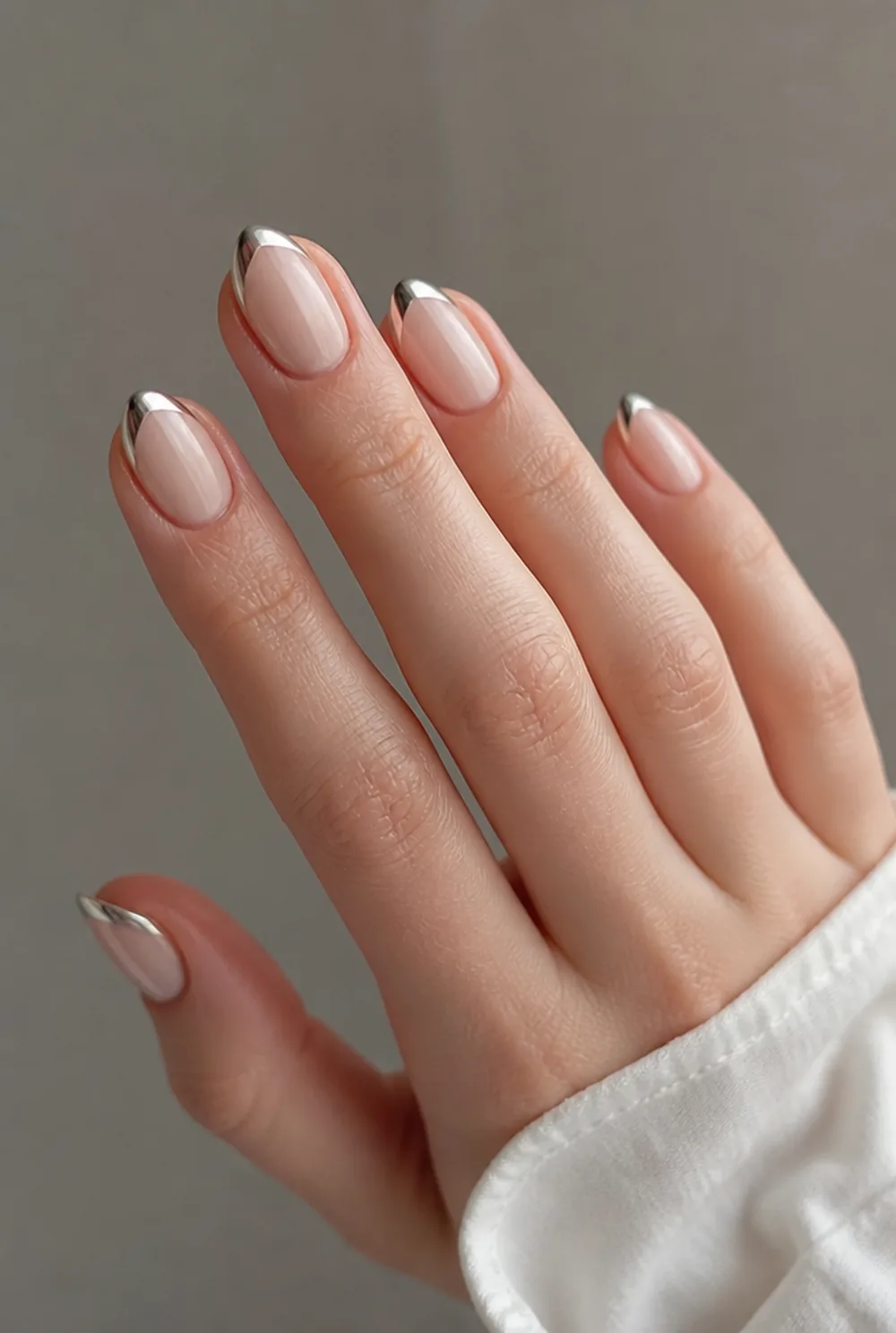 stiletto with chrome tips nail art on fair skin, short length