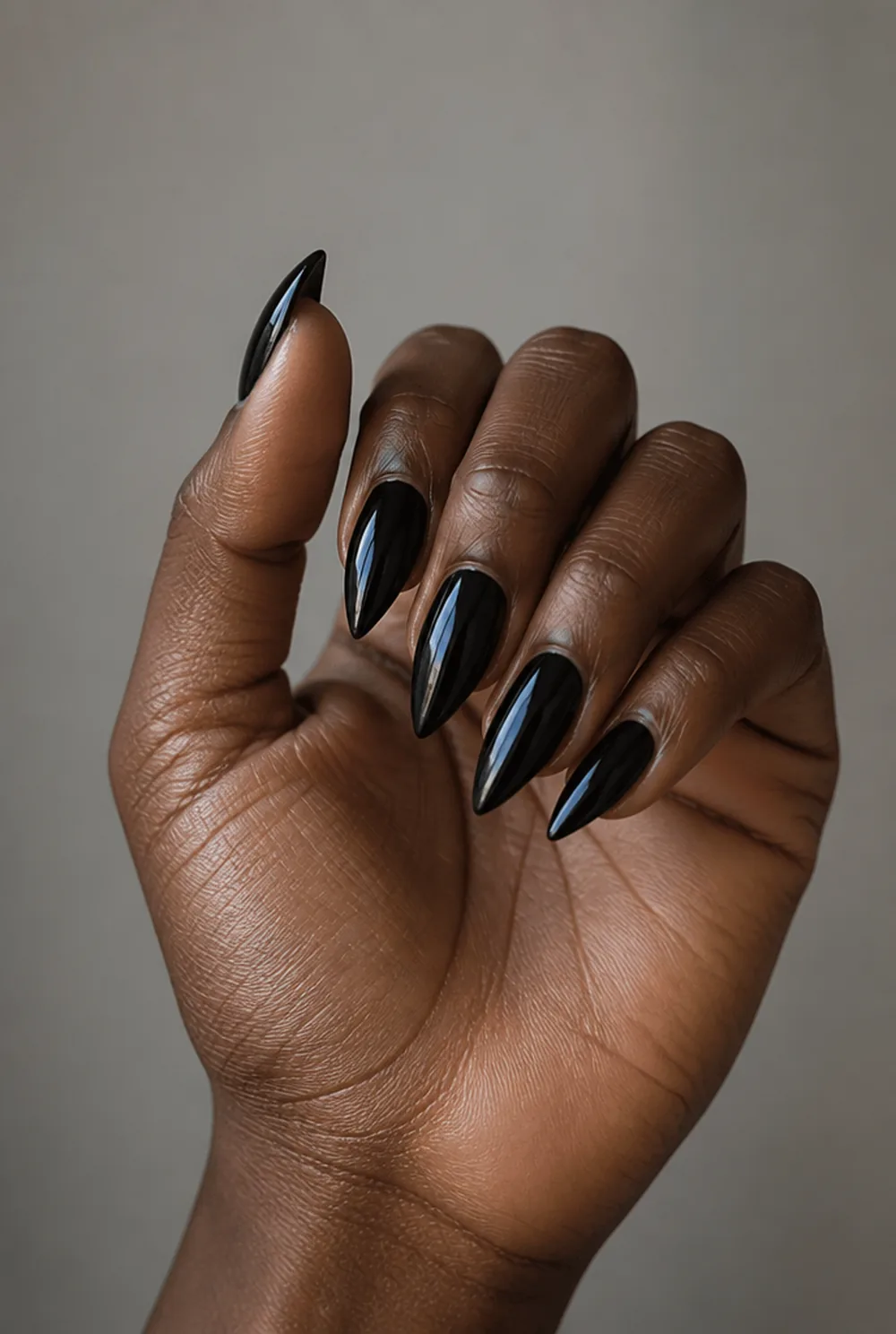 black stiletto nail art on deep brown skin