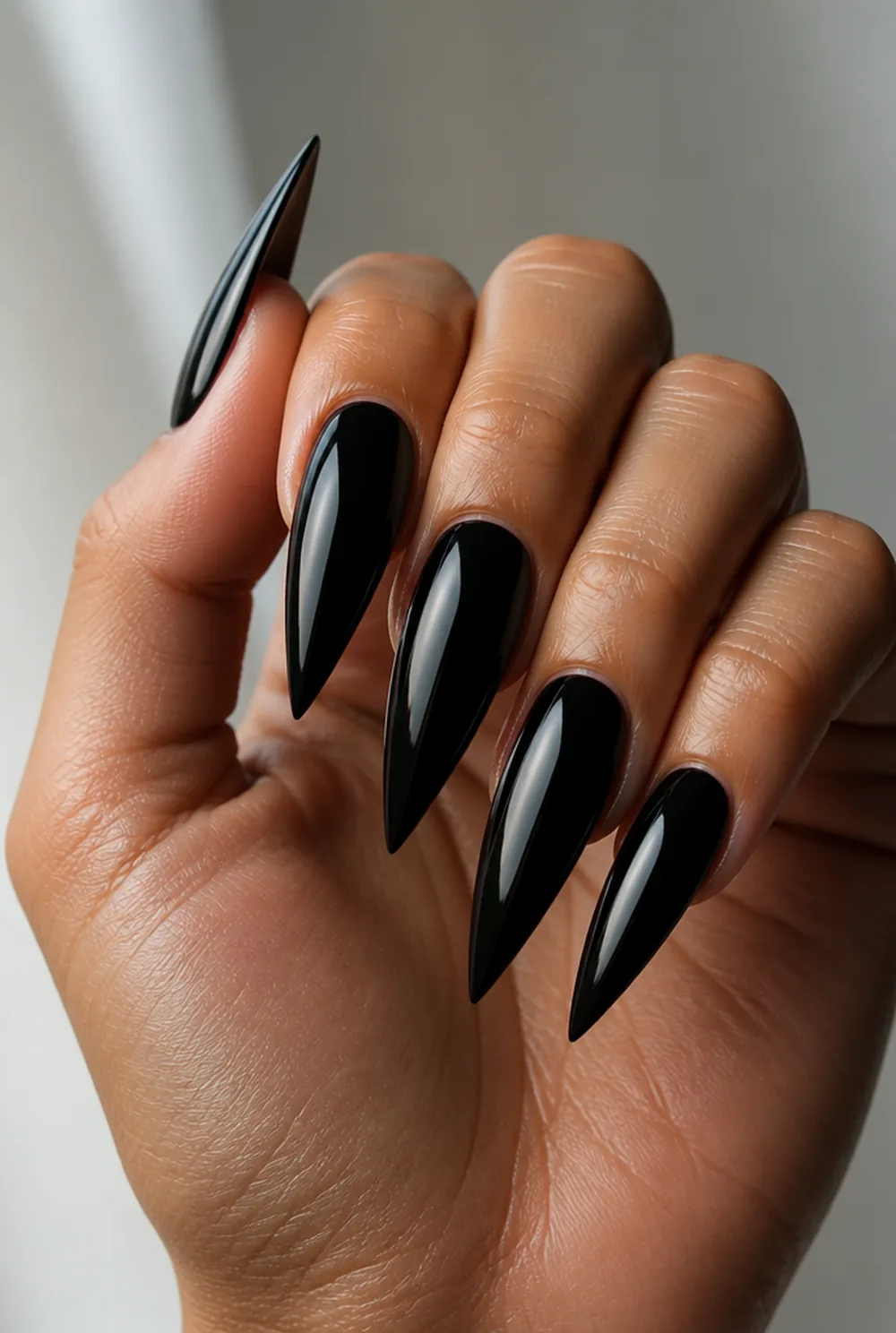 black stiletto nail art on olive skin, long length