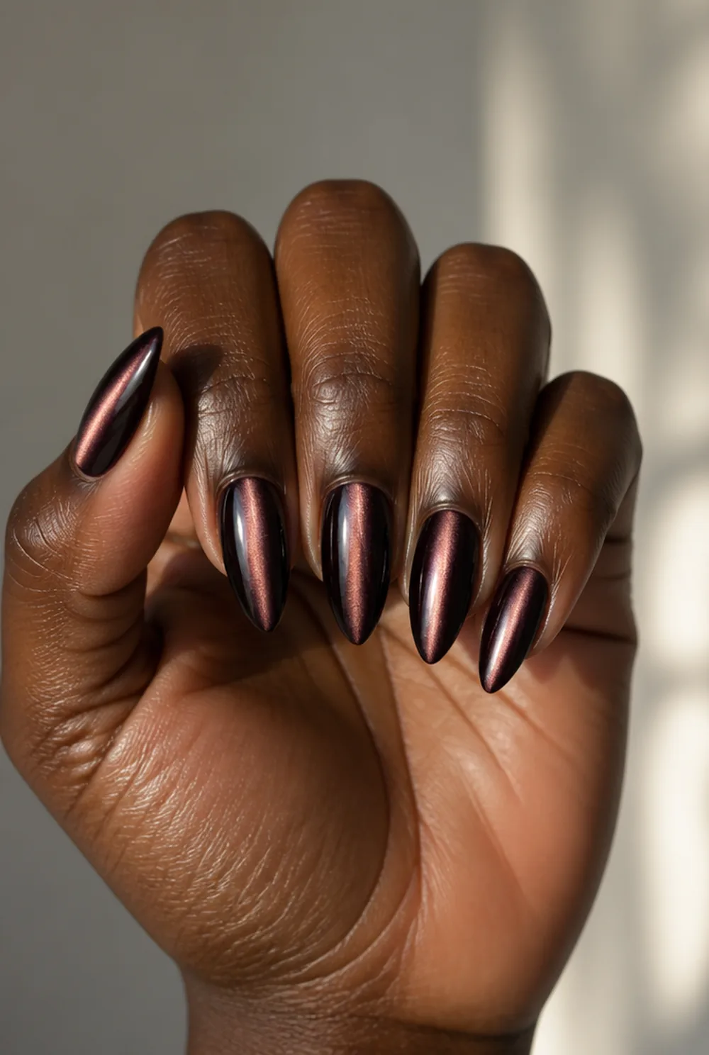 stiletto cat eye nail art on deep brown skin