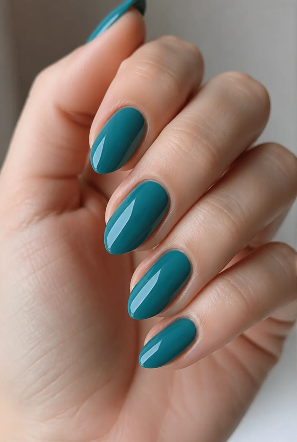 deep teal creme nail art on fair skin, short length